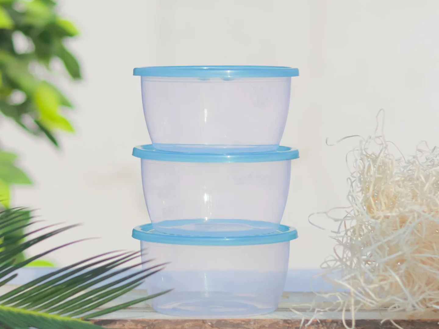 Reusable food containers stacked with matching blue lids.