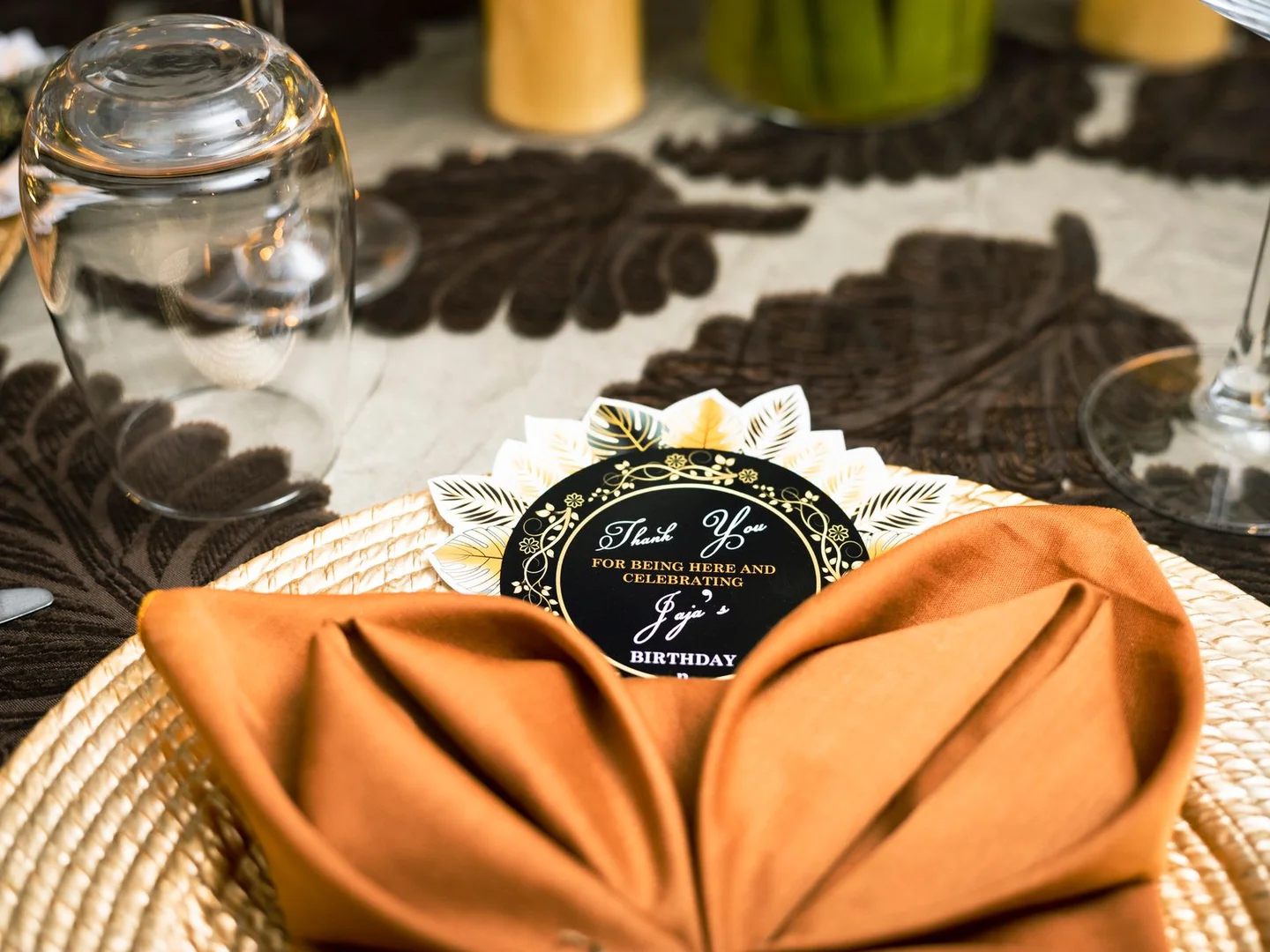 A birthday table setting with cloth napkins and ceramic plates.