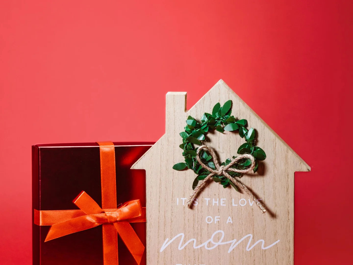 A wrapped gift beside a wooden Mother's Day decoration.