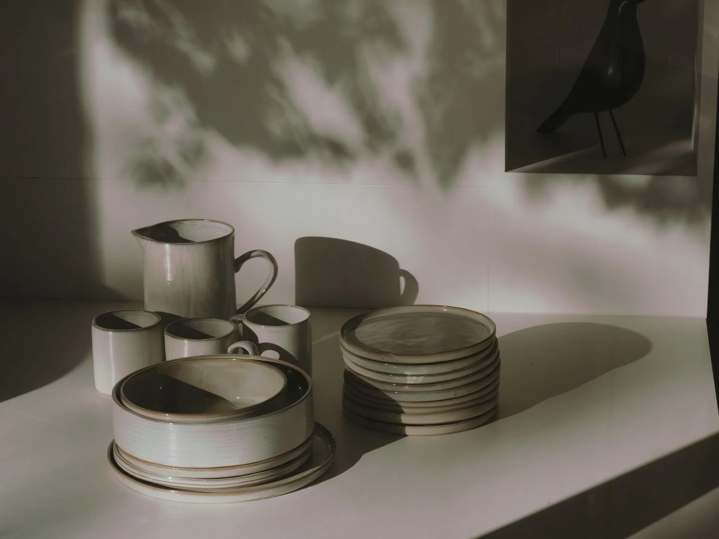 Ceramic dinnerware arranged on a table in bright daylight.