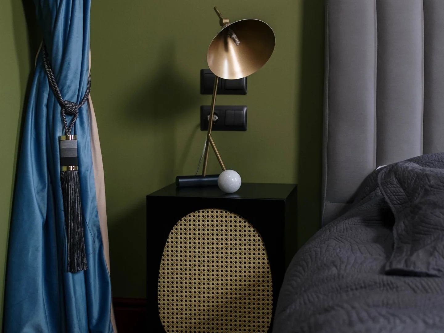 A shaded table lamp on a bedside table.