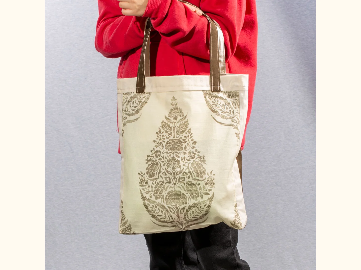 A large printed canvas tote carried by its long handles.