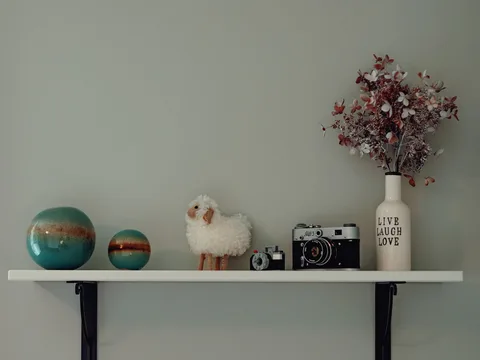 Small decorative objects arranged on a wall shelf.