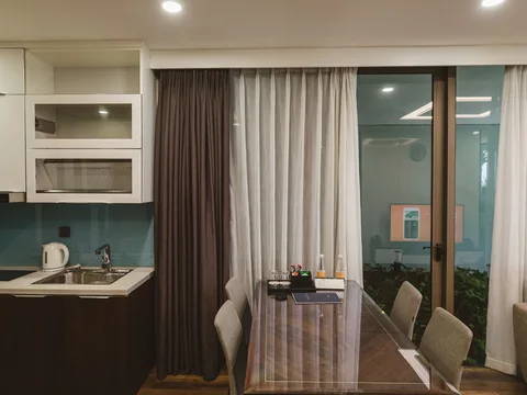 A compact dining table and chairs beside a kitchen.