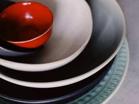 Ceramic plates and bowls in several colors.