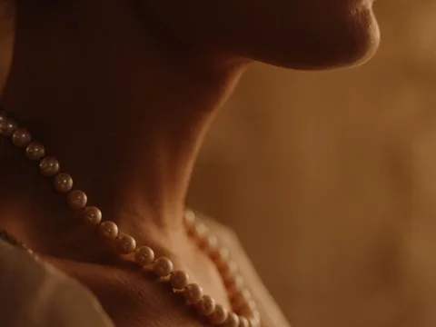 A pearl necklace worn at the neckline.